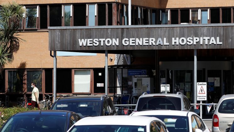 The main entrance to Weston General Hospital in Weston Super Mare. Person seen in the background wearing a face mask during the COVID-19 pandemic.