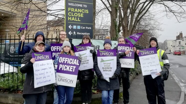 UNISON members hold placards on a picket line outside Francis Close Hall at the University of Gloucestershire.
