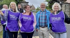 St Monica care staff wear purple UNISON tabbards on strike outside a care home.