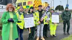 Joanne Kaye on the picket line in Redruth with an ambulance in the background.