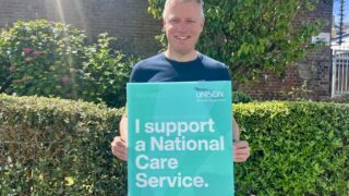 Luke Pollard holds placard that reads 'I support a national care service'