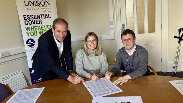 Graham Farrant and Jon Hartley jointly sign the charter. Smiling for the camera.