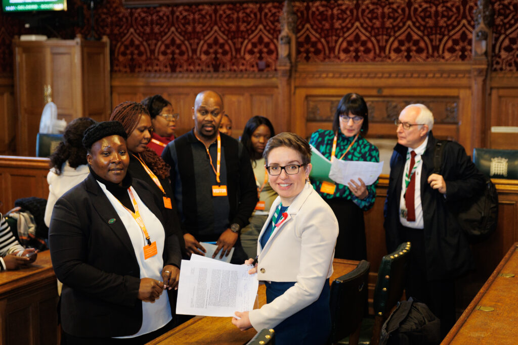 Carla Denyer and Neil Duncan-Jordan seen speaking to migrant workers in Parliament.