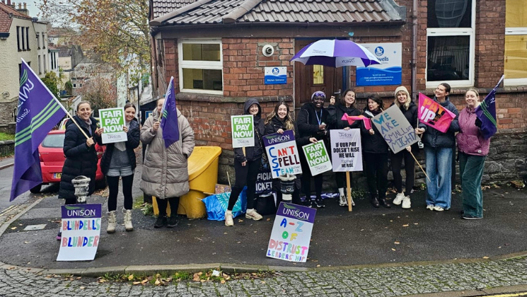 Staff on the picket line outside Hotwells Primary School holding placards and UNISON flags.