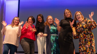 Norfolk Community Health celebrate their award with jazz hands